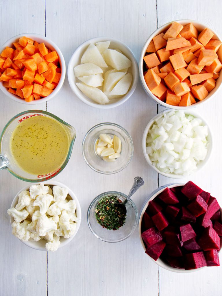 Bowls of ingredients for Red Beauty Vegetable Sauce. Include chopped carrots, chopped sweet potatoes, chopped beets, garlic and more.